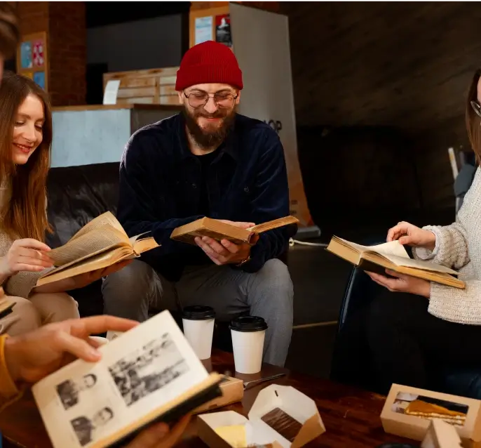 four people sitting together and reading books